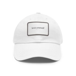 A white Love Yourself Dad Hat with a rectangular patch on the front displaying the words "love yourself" in small, black text.